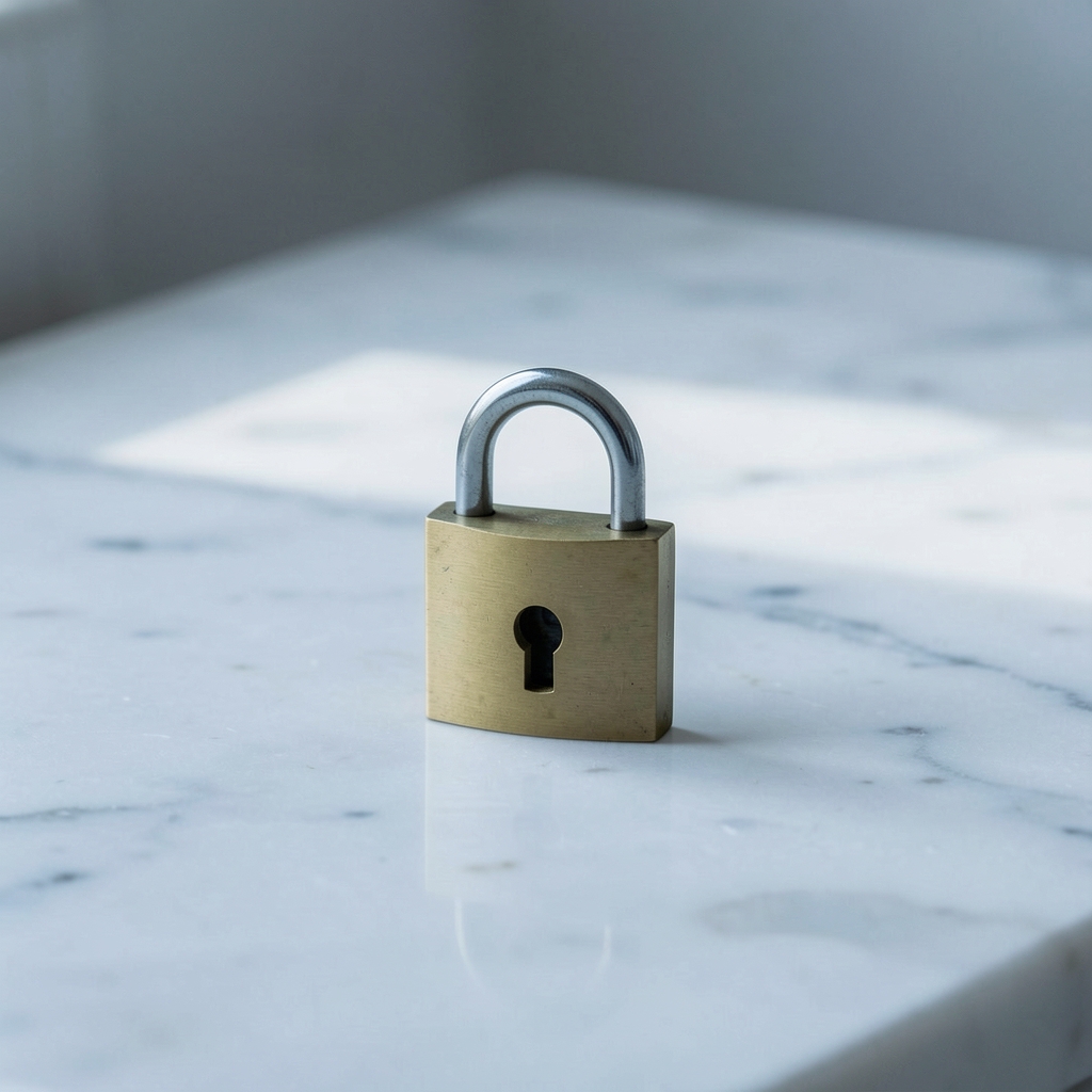 A small brass padlock resting on a clean marble surface, suggesting restricted access and privacy